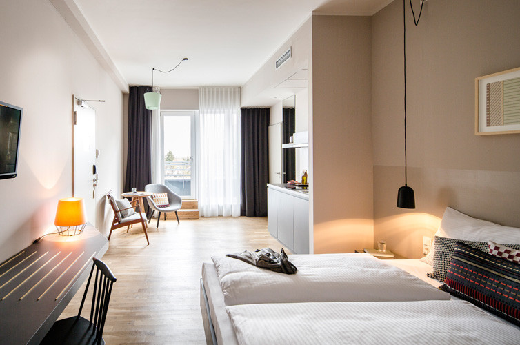 На фото: хозяйская спальня среднего размера в стиле модернизм с бежевыми стенами и паркетным полом среднего тона без камина с