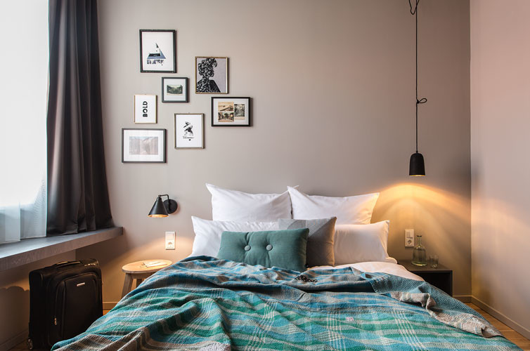 Imagen de dormitorio principal minimalista pequeño sin chimenea con paredes grises y suelo de madera en tonos medios