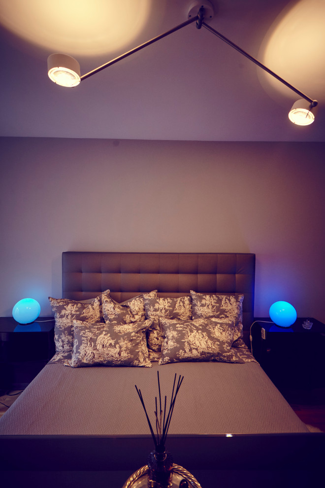 Foto de dormitorio actual con paredes grises y suelo de madera en tonos medios