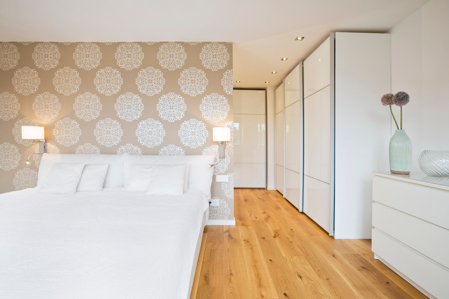ミュンヘンにある広いコンテンポラリースタイルのおしゃれな主寝室 (白い壁、無垢フローリング、暖炉なし、アクセントウォール) のインテリア