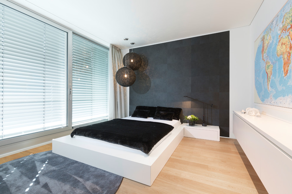 Großes Modernes Schlafzimmer mit weißer Wandfarbe, braunem Boden und hellem Holzboden in Köln