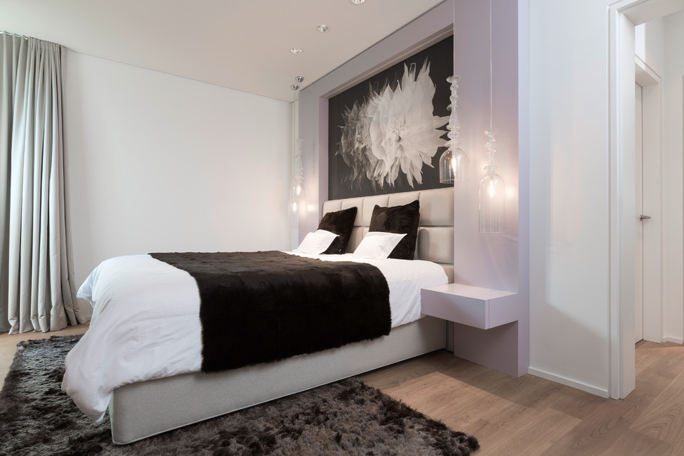 Mittelgroßes Modernes Gästezimmer ohne Kamin mit weißer Wandfarbe, braunem Holzboden und braunem Boden in Köln