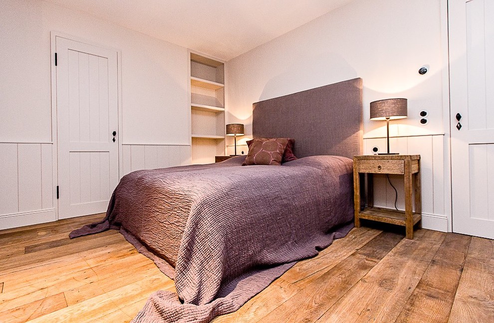 Mittelgroßes Landhaus Hauptschlafzimmer ohne Kamin mit weißer Wandfarbe und braunem Holzboden in Hamburg