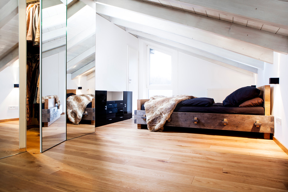 Mittelgroßes Skandinavisches Schlafzimmer ohne Kamin mit weißer Wandfarbe, hellem Holzboden, Kaminumrandung aus Metall und braunem Boden in München