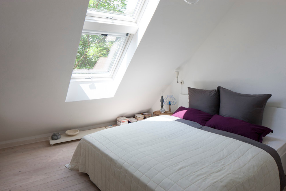 Ejemplo de dormitorio principal rústico pequeño sin chimenea con paredes blancas y suelo de madera clara