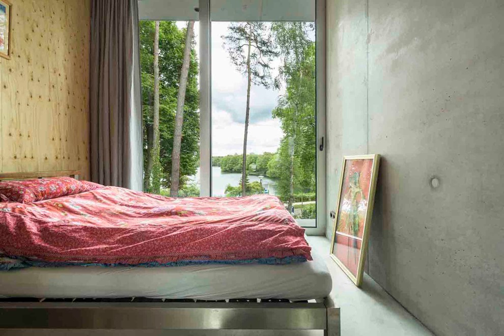 Ispirazione per una camera da letto minimal di medie dimensioni con pareti grigie, pavimento in cemento e nessun camino
