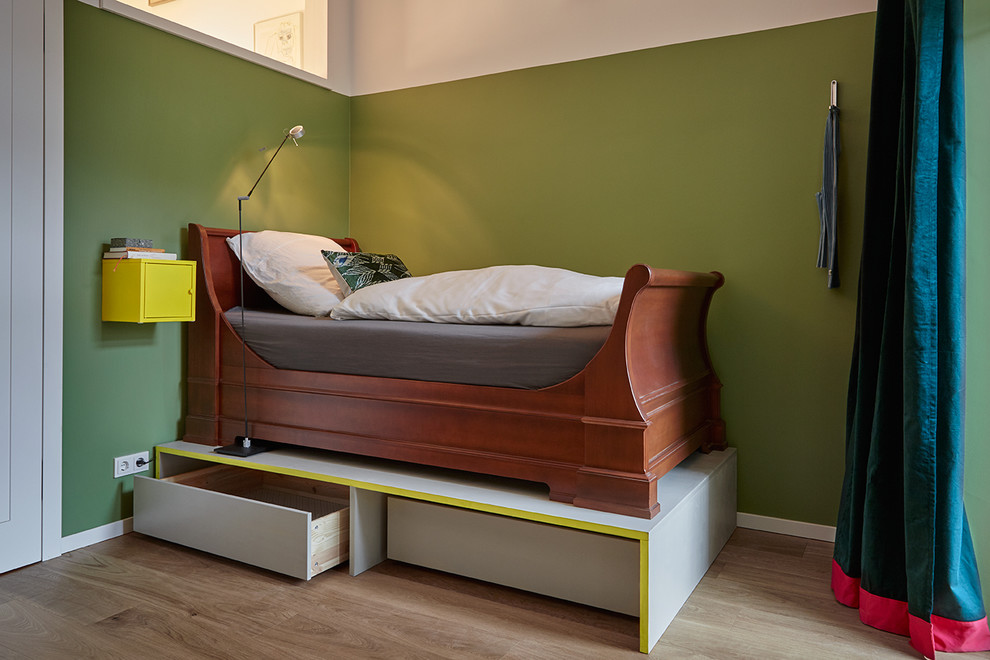 Cette photo montre une petite chambre d'amis rétro avec un mur vert, parquet clair, aucune cheminée et un sol marron.