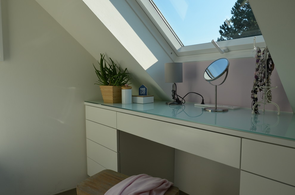 Modelo de dormitorio contemporáneo pequeño con paredes rosas, suelo de cemento y suelo gris