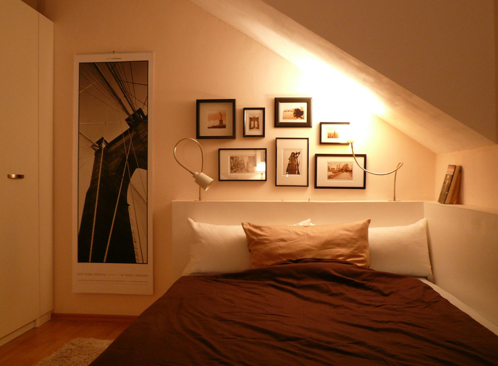 Idee per una camera matrimoniale minimal con pareti multicolore e pavimento in legno massello medio
