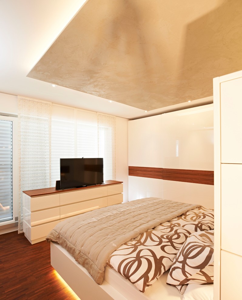 Идея дизайна: хозяйская спальня среднего размера в современном стиле с белыми стенами, паркетным полом среднего тона и коричневым полом без камина