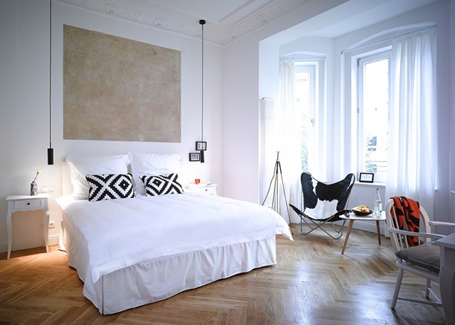 Stilmix Hauptschlafzimmer mit weißer Wandfarbe und braunem Holzboden in Berlin