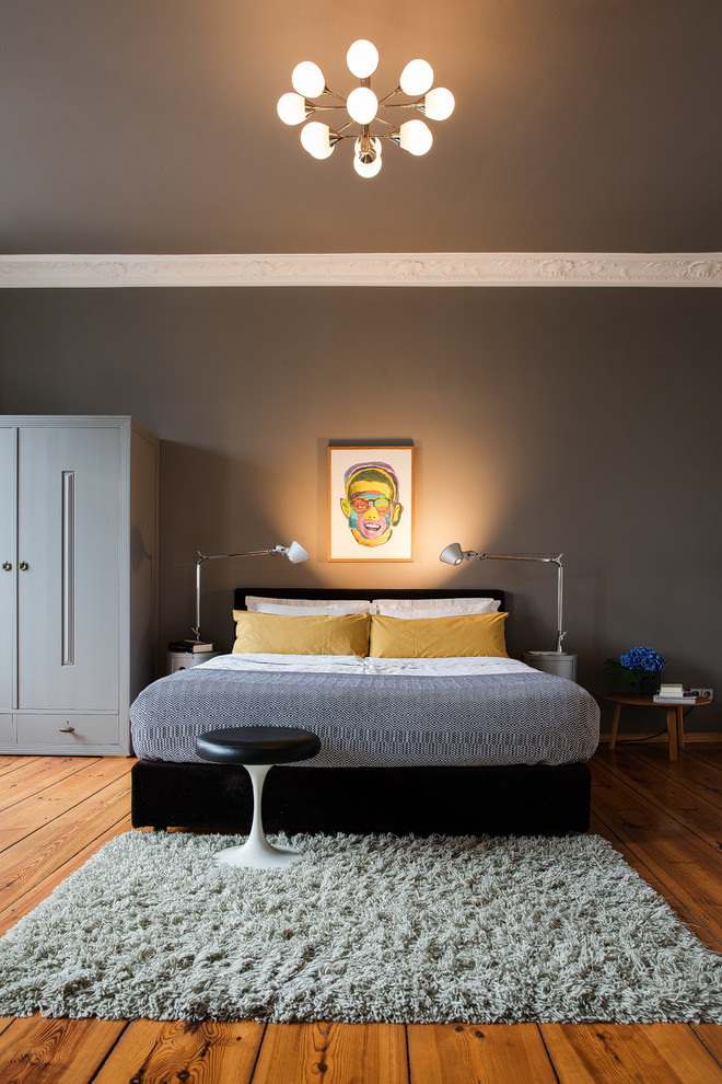 This is an example of a medium sized contemporary master bedroom in Berlin with grey walls, light hardwood flooring and brown floors.