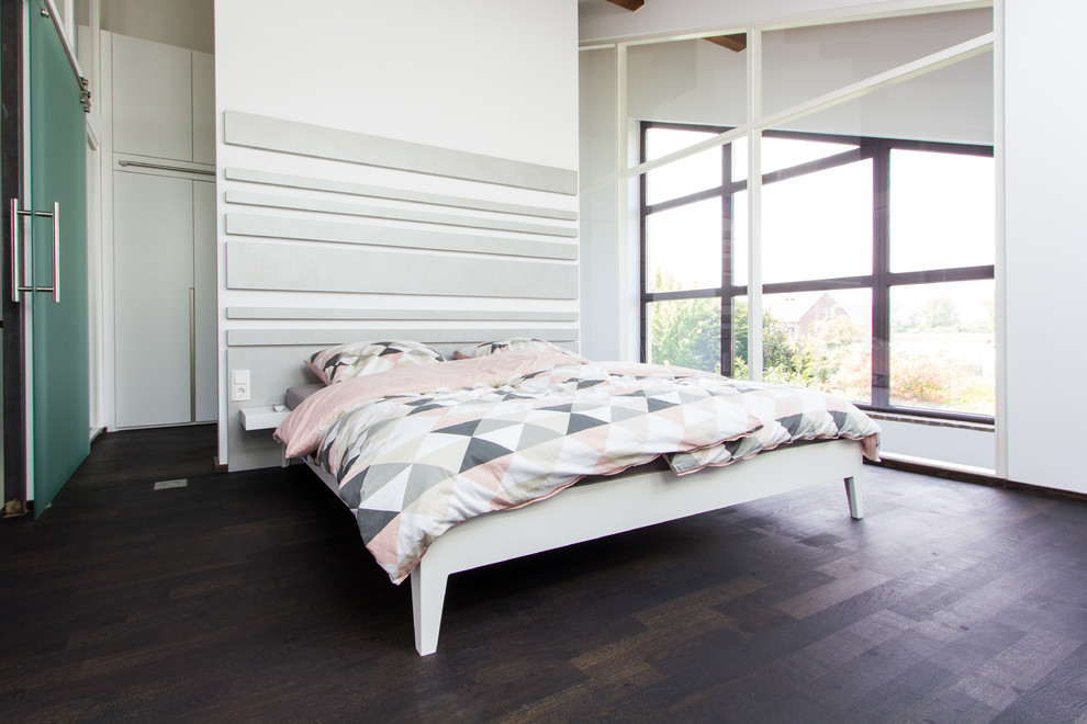 Стильный дизайн: большая хозяйская спальня в стиле лофт с темным паркетным полом, белыми стенами и коричневым полом без камина - последний тренд