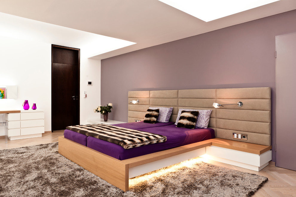 Exemple d'une grande chambre parentale tendance avec un mur violet, un sol en bois brun et aucune cheminée.