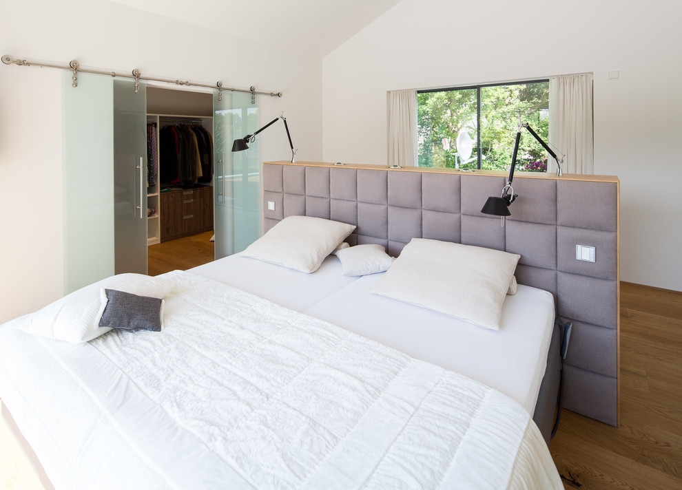 Großes Modernes Hauptschlafzimmer ohne Kamin mit weißer Wandfarbe und braunem Holzboden in Bremen