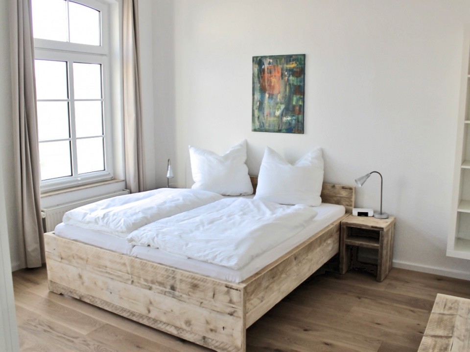 Immagine di una camera da letto stile rurale di medie dimensioni con pareti bianche, pavimento in legno massello medio e nessun camino