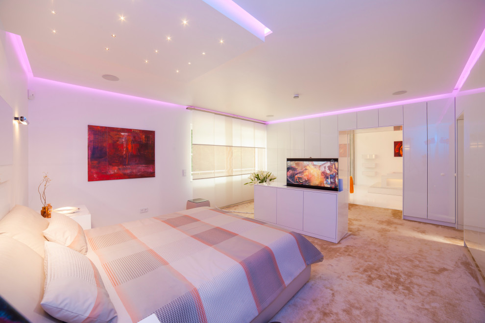 Modelo de dormitorio principal moderno extra grande con paredes blancas, moqueta y suelo beige