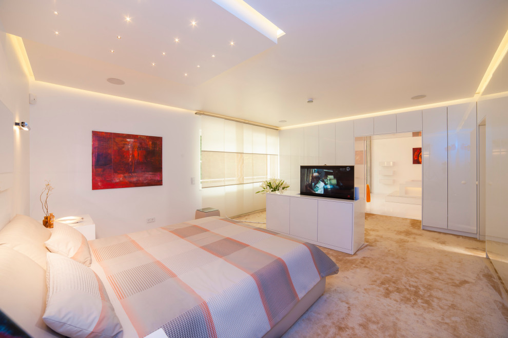 Immagine di un'ampia camera matrimoniale minimalista con pareti bianche, moquette e pavimento beige