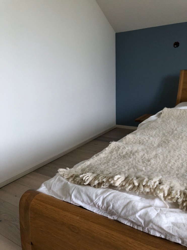 На фото: хозяйская спальня среднего размера в современном стиле с синими стенами, паркетным полом среднего тона и коричневым полом