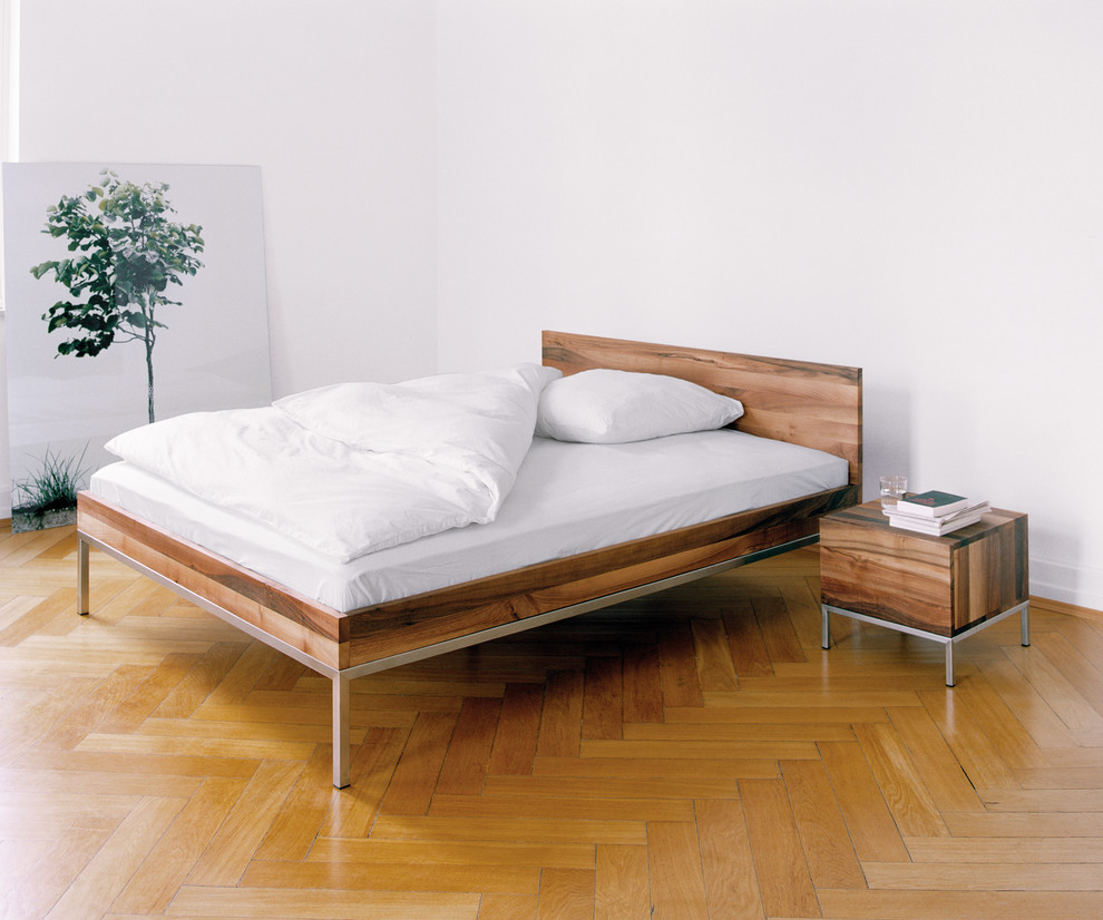 Modernes Schlafzimmer ohne Kamin mit weißer Wandfarbe und braunem Holzboden in Frankfurt am Main