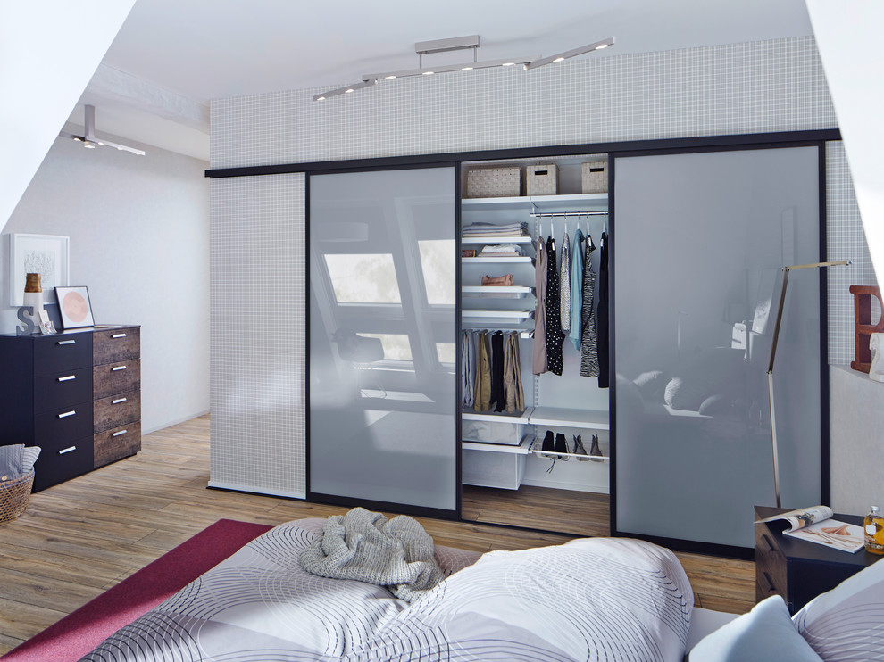 Diseño de dormitorio principal nórdico grande con paredes grises y suelo de madera en tonos medios