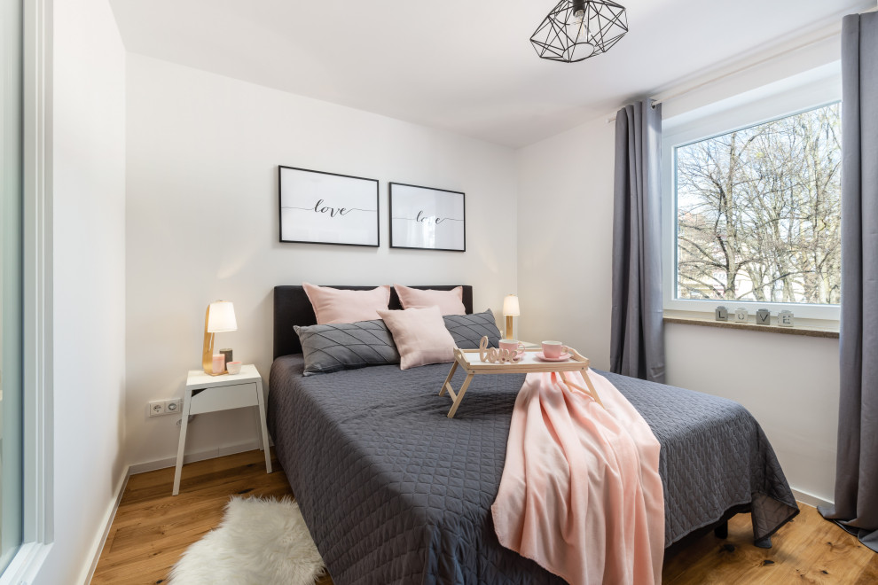 Mittelgroßes Skandinavisches Schlafzimmer mit weißer Wandfarbe, braunem Holzboden und braunem Boden in München