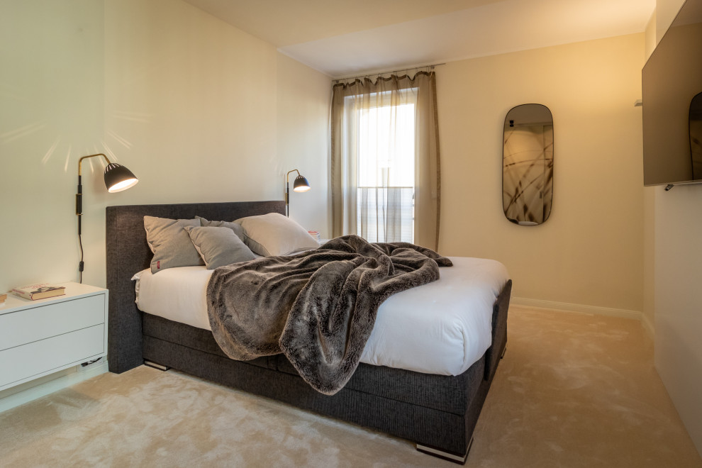 Imagen de habitación de invitados actual de tamaño medio con paredes amarillas, moqueta y suelo beige