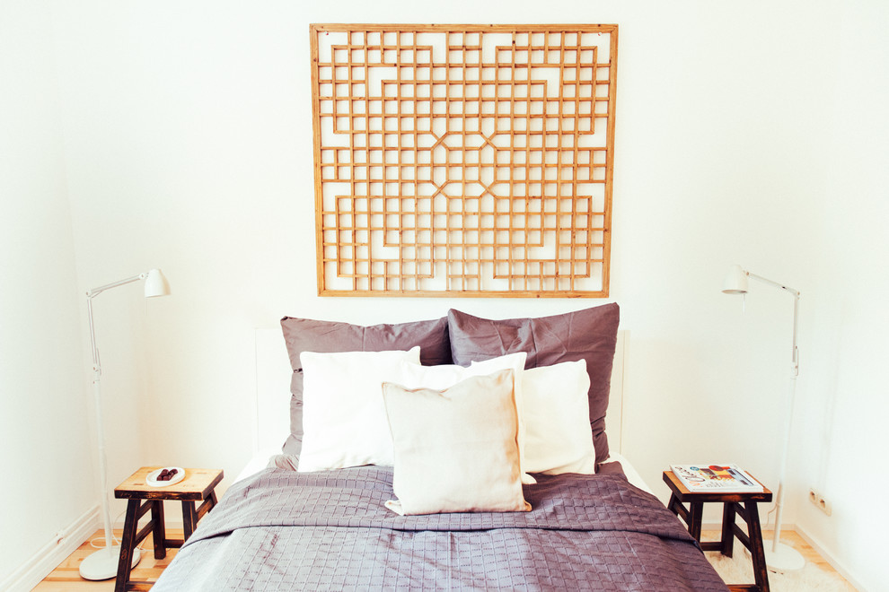 Foto på ett litet orientaliskt sovrum, med vita väggar och mellanmörkt trägolv