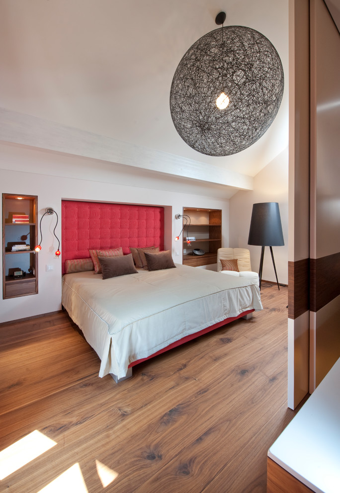Großes Modernes Hauptschlafzimmer ohne Kamin mit weißer Wandfarbe, braunem Holzboden und braunem Boden in Sonstige