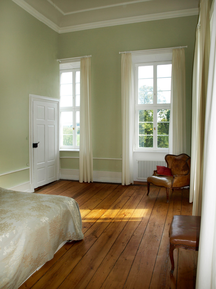 Aménagement d'une grande chambre d'amis campagne avec un mur vert, parquet clair, aucune cheminée et un sol marron.