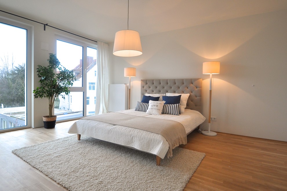Großes Nordisches Hauptschlafzimmer ohne Kamin mit weißer Wandfarbe und hellem Holzboden in Bremen