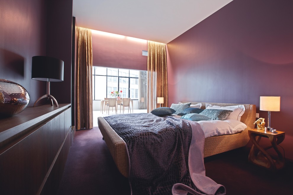 Diseño de dormitorio principal actual de tamaño medio sin chimenea con paredes púrpuras y moqueta