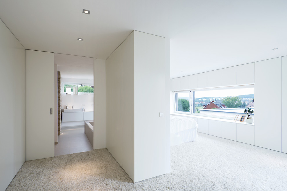 Modernes Hauptschlafzimmer mit weißer Wandfarbe und Teppichboden in Nürnberg