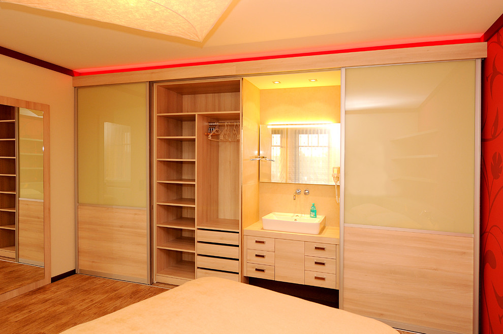 Foto de dormitorio principal contemporáneo grande sin chimenea con paredes beige y suelo de madera en tonos medios