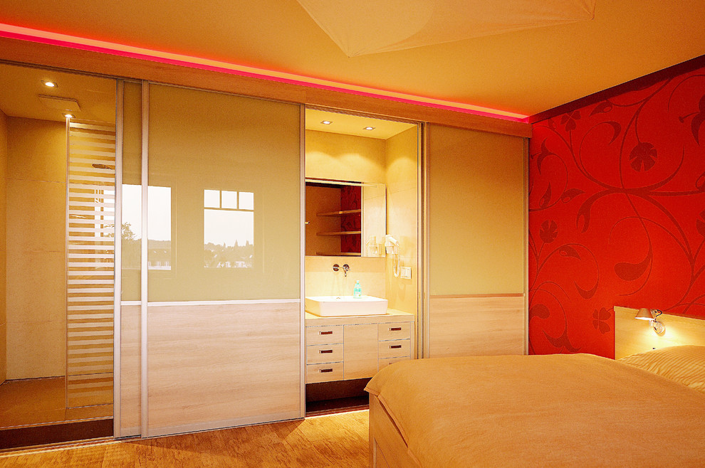 Inspiration pour une grande chambre parentale design avec un mur rouge et un sol en bois brun.