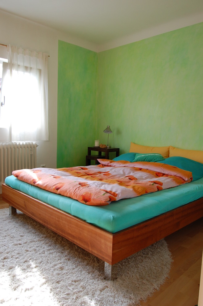 На фото: хозяйская спальня среднего размера в современном стиле с зелеными стенами, ковровым покрытием и бежевым полом с