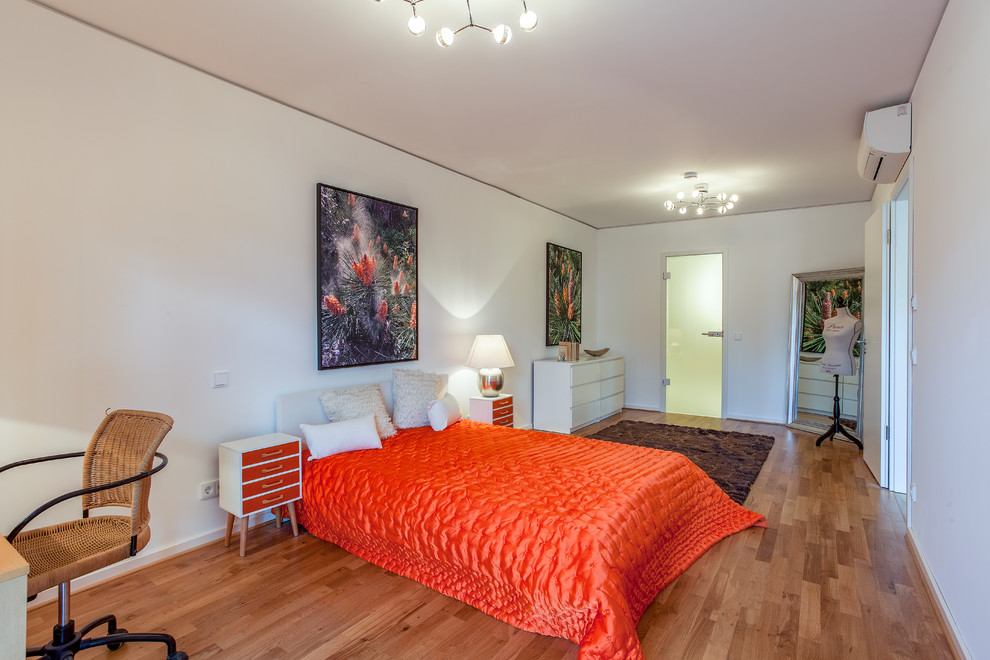 Großes Retro Hauptschlafzimmer ohne Kamin mit weißer Wandfarbe, braunem Holzboden und braunem Boden in Berlin