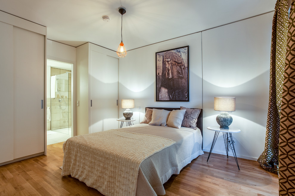 Großes Modernes Hauptschlafzimmer ohne Kamin mit weißer Wandfarbe, braunem Holzboden und braunem Boden in Berlin