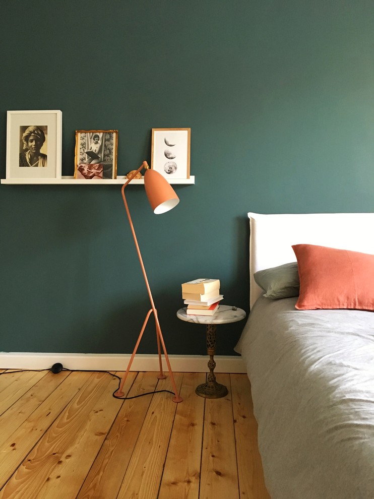Medium sized scandi master bedroom in Berlin with green walls, light hardwood flooring, no fireplace and beige floors.