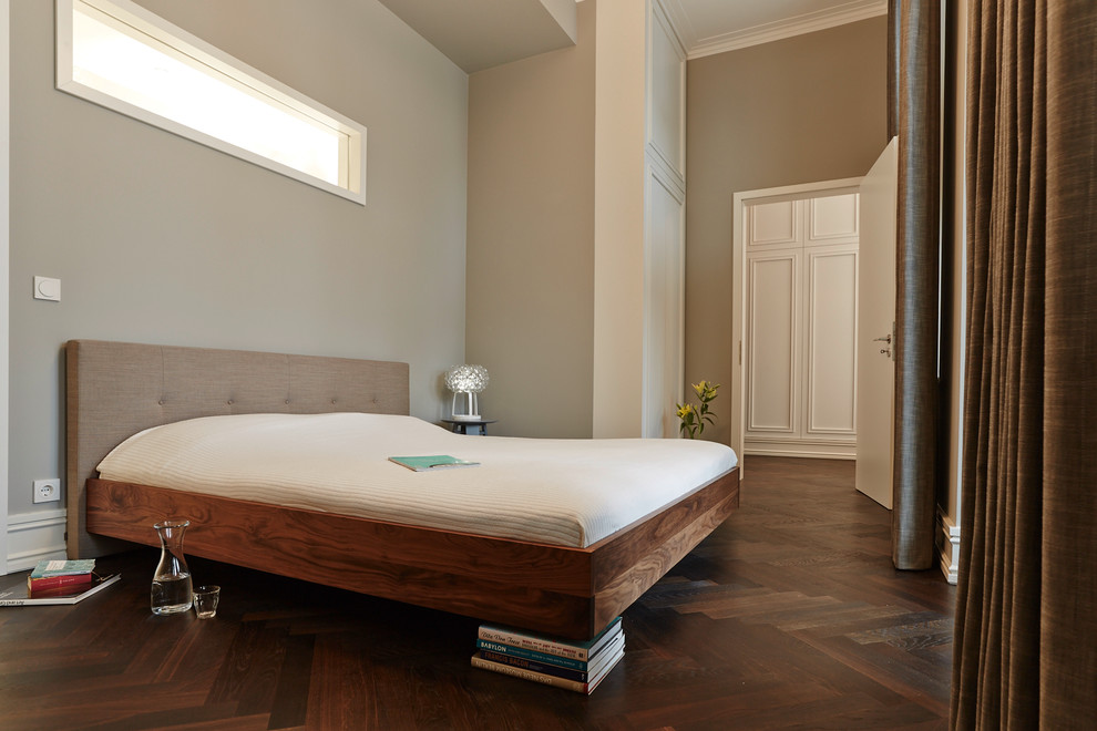 Пример оригинального дизайна: хозяйская спальня среднего размера в современном стиле с серыми стенами, паркетным полом среднего тона и коричневым полом без камина