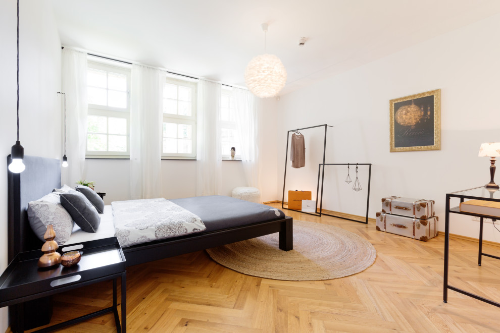 Modernes Schlafzimmer mit weißer Wandfarbe, braunem Holzboden und braunem Boden in Essen