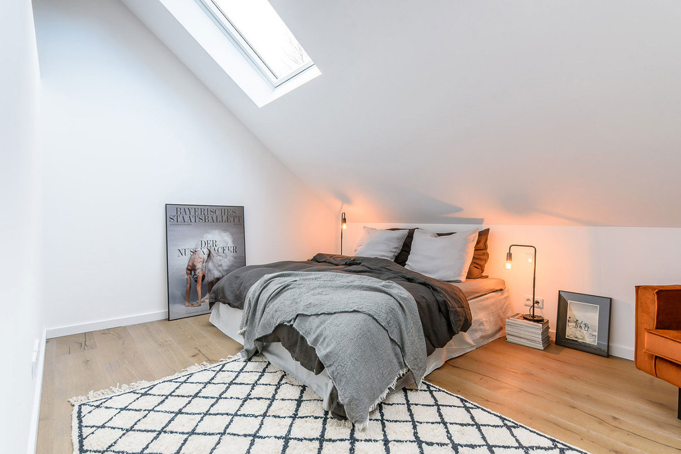 Kleines Nordisches Hauptschlafzimmer ohne Kamin mit weißer Wandfarbe, braunem Holzboden und braunem Boden in München