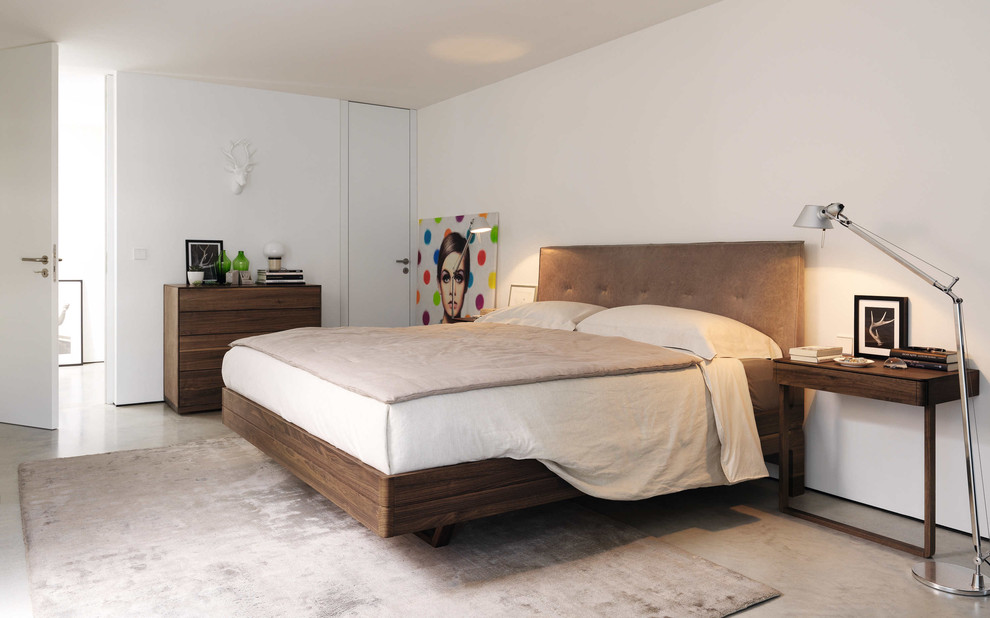 Großes Modernes Hauptschlafzimmer ohne Kamin mit weißer Wandfarbe und grauem Boden in Nürnberg