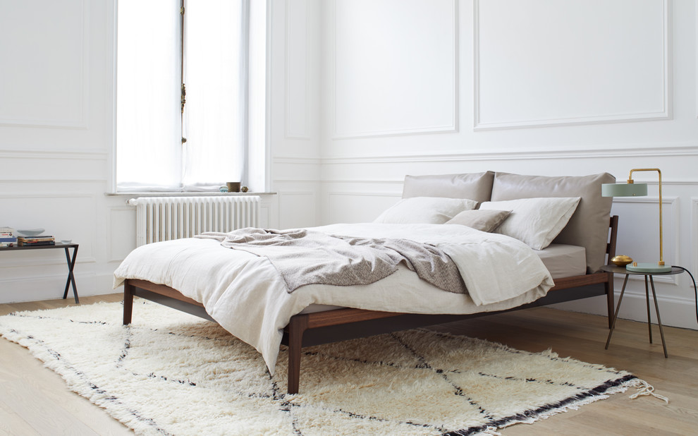Medium sized scandinavian master bedroom in Hamburg with white walls, medium hardwood flooring and brown floors.