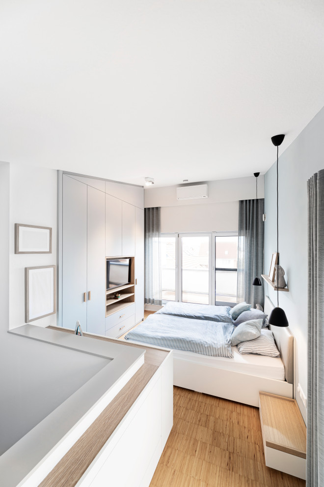 Modelo de dormitorio principal nórdico de tamaño medio con paredes blancas