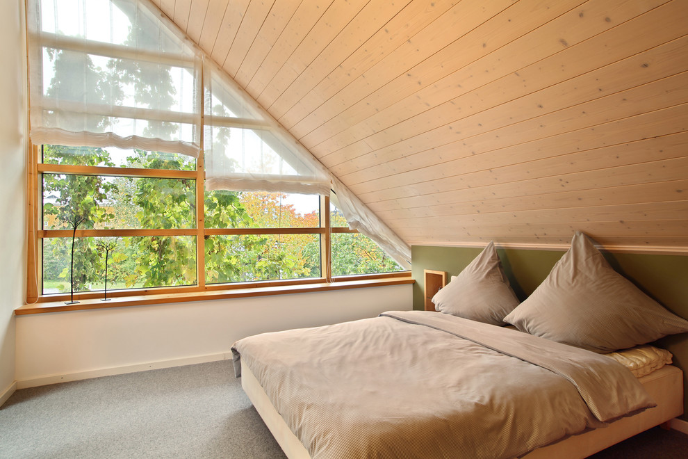 На фото: хозяйская спальня среднего размера на мансарде в скандинавском стиле с белыми стенами и ковровым покрытием без камина с