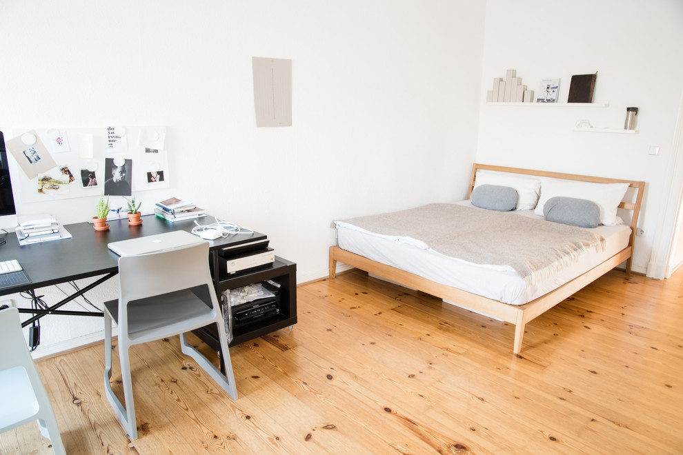 Großes Skandinavisches Schlafzimmer mit weißer Wandfarbe und braunem Holzboden in Berlin
