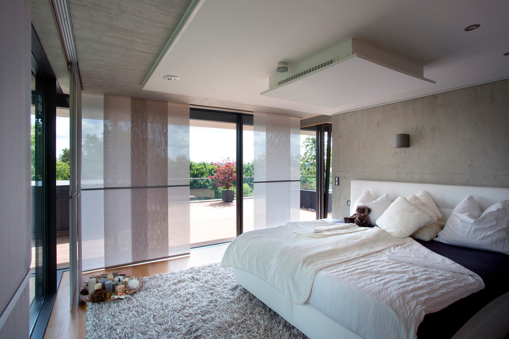 Mittelgroßes Modernes Hauptschlafzimmer ohne Kamin mit grauer Wandfarbe, braunem Holzboden und braunem Boden