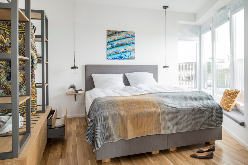 Modernes Schlafzimmer mit weißer Wandfarbe, braunem Holzboden und braunem Boden in Hamburg