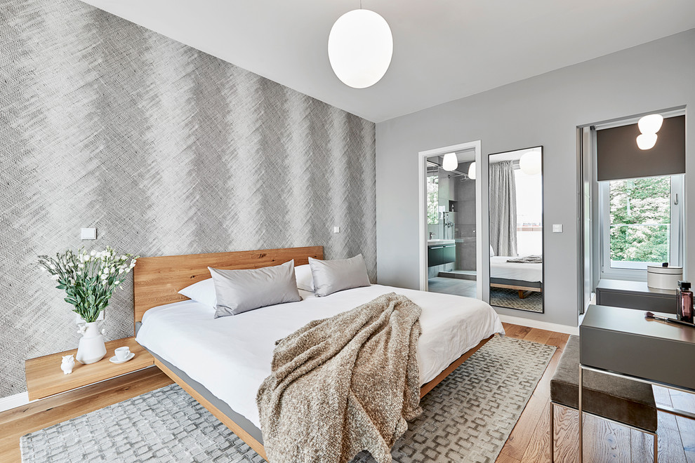 Mittelgroßes Modernes Hauptschlafzimmer ohne Kamin mit grauer Wandfarbe, braunem Holzboden und braunem Boden in Hamburg